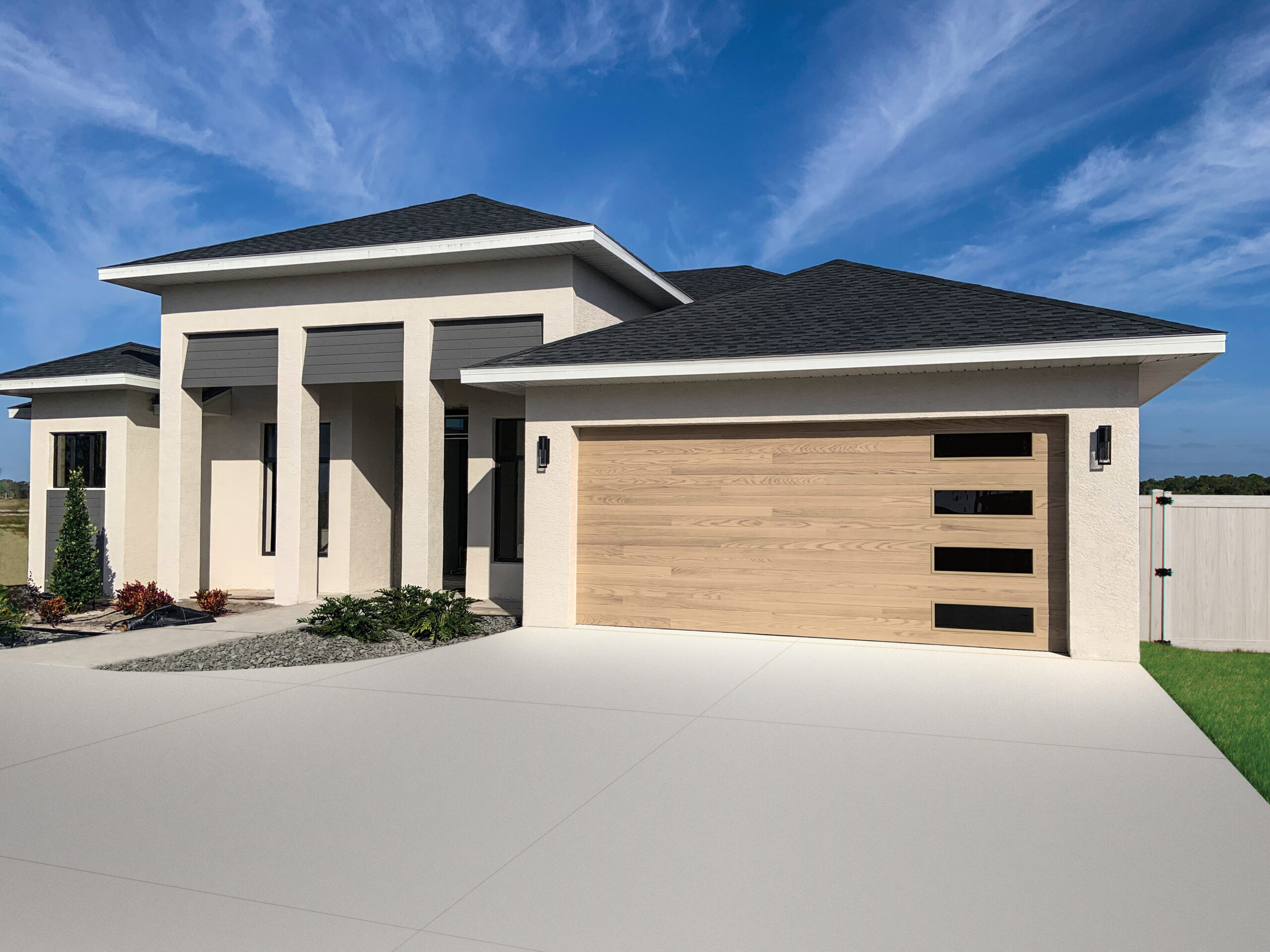 Coastal home with natural oak wood-look planks garage door